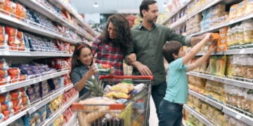 Family with two children doing the grocery shopping in supermarket