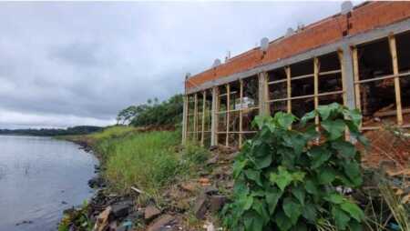 La construcción del hotel "Lagier" sobre la avenida Martín Fierro, en la costa del río Paraná de Candelaria, continúa avanzando pese a las múltiples intimaciones del Ministerio de Ecología de Misiones, que ya realizó cuatro intervenciones en el lugar. El propietario sostiene que cuenta con las autorizaciones correspondientes, pero los vecinos cuestionan la obra porque afecta la visual del paisaje y limita el acceso al sector costero. El director de Ecología de Misiones, Franco García, explicó que el pasado martes realizaron una nueva intervención en el lugar porque les comunicaron que la obra había continuado. "Esta ya es la cuarta intervención que se hace, en donde hemos evidenciado que la obra continúa y hemos realizado una nueva acta intimando el cese inmediato", precisó el funcionario. García señaló que los ecosistemas de los bordes ribereños son altamente frágiles y que el ministerio ya realizó los informes correspondientes, los cuales fueron derivados al área jurídica para que determine las presuntas infracciones a las leyes ambientales. "Mientras se sustancie el sumario, debe cesar la obra", afirmó, y agregó que el área jurídica definirá si existen infracciones. El funcionario detalló el cronograma de intervenciones: la primera fue el 4 de junio, la segunda el 10 de junio, donde decomisaron los elementos utilizados, luego una tercera a cargo de la Dirección General de Bosque Nativo, y finalmente la cuarta intervención para intimar el cese inmediato. "Estas sumatorias de actas van siendo agravantes", advirtió. Consultado sobre la posibilidad de un derrumbe, García explicó que una vez finalizado el sumario, el área jurídica determinará las medidas a tomar. "Puede ser una de las posibilidades, no quiere decir que sea la definitiva, pero puede ser una de las posibilidades de la eliminación de la obra", sostuvo. El director señaló que, ante el incumplimiento, apelan a la voluntad del propietario, pero que la obra sigue avanzando, por lo que continuarán interviniendo. "Eso va a seguir sumando agravante a la multa final", afirmó, y agregó que una de las vías posibles es una denuncia ante la justicia penal. La polémica obra del hotel sobre la costa del río Paraná continúa en Candelaria pese a las intimaciones