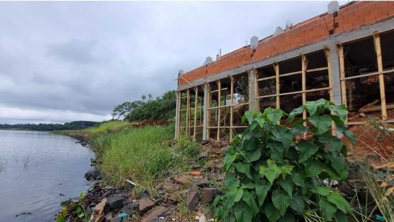 La construcción del hotel "Lagier" sobre la avenida Martín Fierro, en la costa del río Paraná de Candelaria, continúa avanzando pese a las múltiples intimaciones del Ministerio de Ecología de Misiones, que ya realizó cuatro intervenciones en el lugar. El propietario sostiene que cuenta con las autorizaciones correspondientes, pero los vecinos cuestionan la obra porque afecta la visual del paisaje y limita el acceso al sector costero. El director de Ecología de Misiones, Franco García, explicó que el pasado martes realizaron una nueva intervención en el lugar porque les comunicaron que la obra había continuado. "Esta ya es la cuarta intervención que se hace, en donde hemos evidenciado que la obra continúa y hemos realizado una nueva acta intimando el cese inmediato", precisó el funcionario. García señaló que los ecosistemas de los bordes ribereños son altamente frágiles y que el ministerio ya realizó los informes correspondientes, los cuales fueron derivados al área jurídica para que determine las presuntas infracciones a las leyes ambientales. "Mientras se sustancie el sumario, debe cesar la obra", afirmó, y agregó que el área jurídica definirá si existen infracciones. El funcionario detalló el cronograma de intervenciones: la primera fue el 4 de junio, la segunda el 10 de junio, donde decomisaron los elementos utilizados, luego una tercera a cargo de la Dirección General de Bosque Nativo, y finalmente la cuarta intervención para intimar el cese inmediato. "Estas sumatorias de actas van siendo agravantes", advirtió. Consultado sobre la posibilidad de un derrumbe, García explicó que una vez finalizado el sumario, el área jurídica determinará las medidas a tomar. "Puede ser una de las posibilidades, no quiere decir que sea la definitiva, pero puede ser una de las posibilidades de la eliminación de la obra", sostuvo. El director señaló que, ante el incumplimiento, apelan a la voluntad del propietario, pero que la obra sigue avanzando, por lo que continuarán interviniendo. "Eso va a seguir sumando agravante a la multa final", afirmó, y agregó que una de las vías posibles es una denuncia ante la justicia penal. La polémica obra del hotel sobre la costa del río Paraná continúa en Candelaria pese a las intimaciones